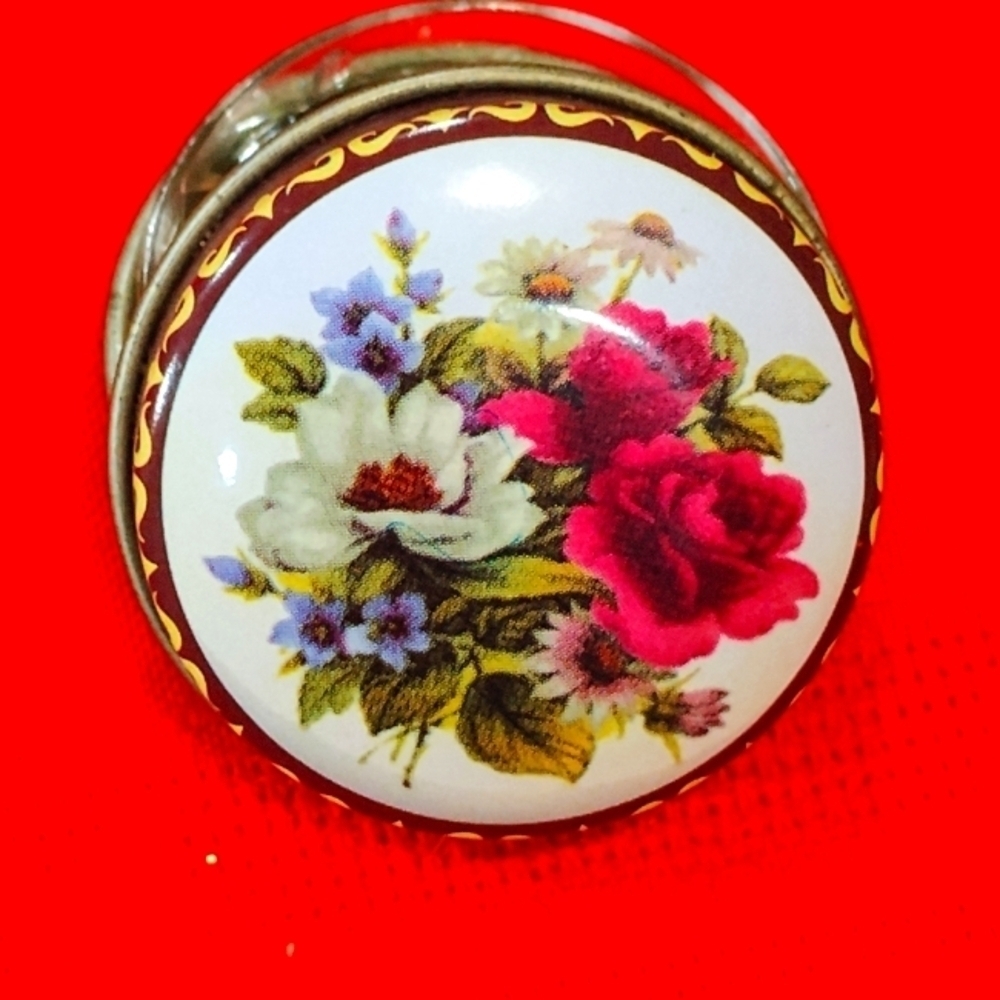 Vintage round metal pill box with floral print.
